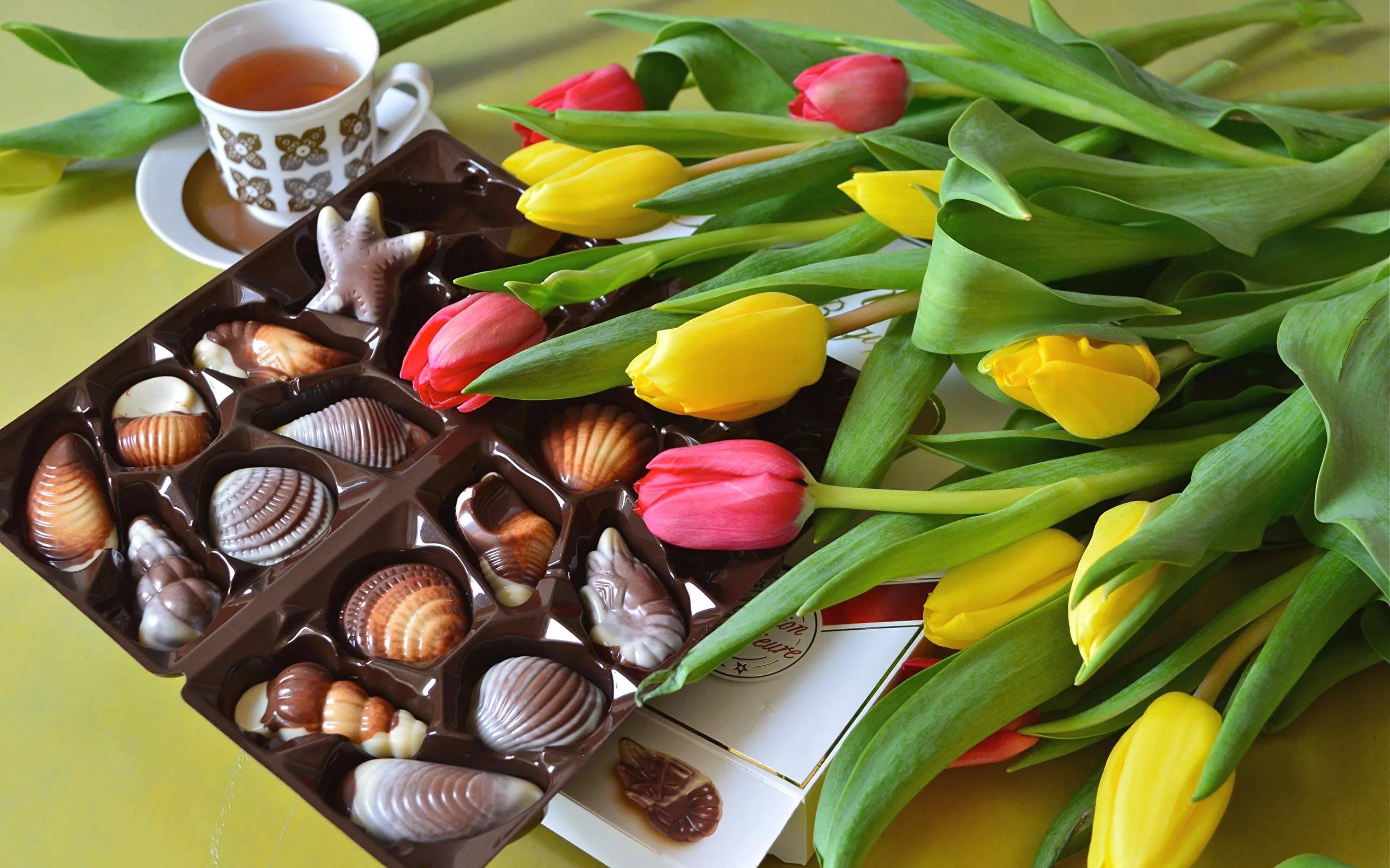 Цветы и шоколадка. Шоколадные конфеты. Цветы с конфетами. Красивые конфеты. Шоколадные конфеты и цветы.